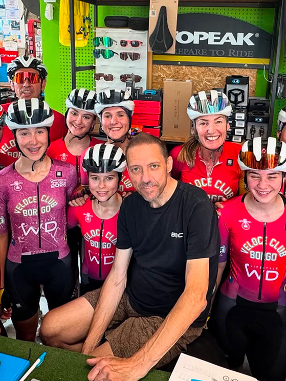 Stefano Casagranda nel suo negozio con i ragazzi del Veloce Club Borgo