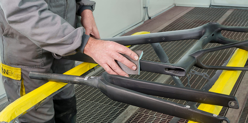 Il telaio in carbonio viene carteggiato per eliminare le irregolarità e poi si passa alla verniciatura