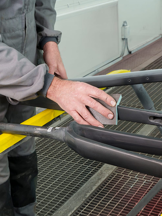 Il telaio in carbonio viene carteggiato per eliminare le irregolarità e poi si passa alla verniciatura